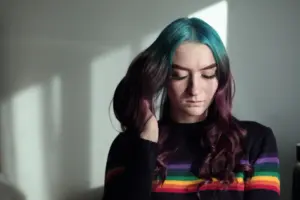 Mädchen mit bunten Haaren schaut nach unten